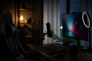 Mörkt streamingrum med mikrofon, ringljus, skärm och gamingstol